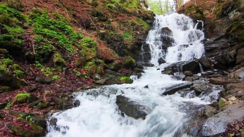 Waterfall Flowing Through Rocks in Lush Nature
