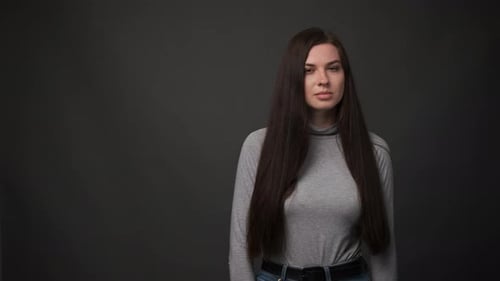 Woman Makes Various Facial Expressions Against Grey Background