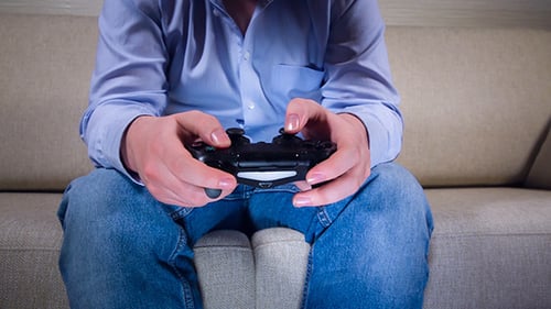 Adult Playing Video Game with Controller Indoors
