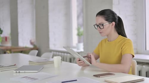 Focused Young Female Designer Working on Tablet in Modern Office