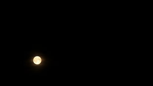 Vollmond zieht über bewölktem Nachthimmel