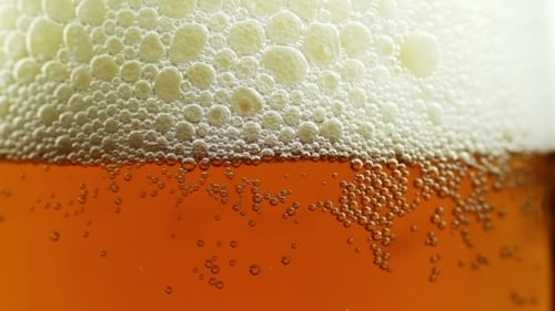 Beer Pouring Into Glass With Bubbly Foam