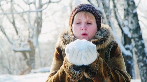 Woman Blowing Snow from Hands in Winter Park