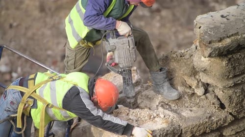 Construction Workers Demolishing Concrete With Jackhammer
