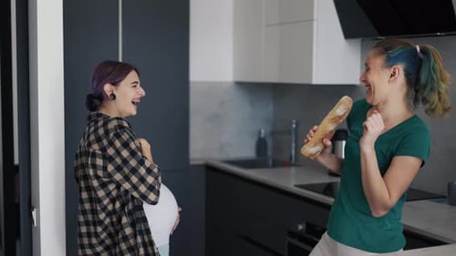 Pregnant Woman Dancing with Bread Mic with Friend