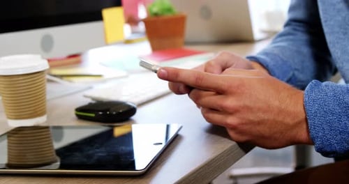 Man Typing on Smartphone in Office Environment