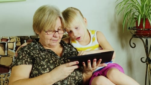 Girl and Adult Using Touchscreen Tablet Together