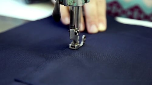Frau näht Kleidung in der Werkstatt