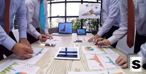 Businessmen Analyzing Data and Charts in Modern Office
