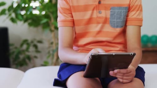 Junge benutzt digitales Tablet auf dem Bett 4k