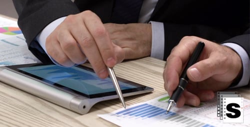 Businessmen Working With Charts and Tablet at Table