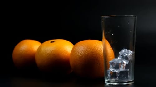 Orange Juice Being Poured into Glass with Ice