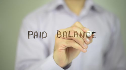 Hand Writing Paid Balance on Glass Surface