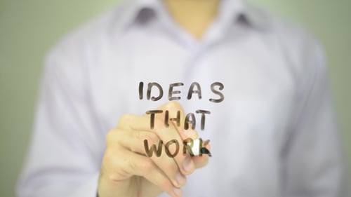 Hand Writes 'Ideas That Work' on Transparent Surface
