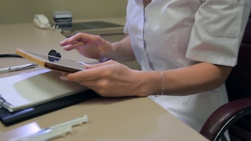 Female Doctor Using Tablet At The Workplace