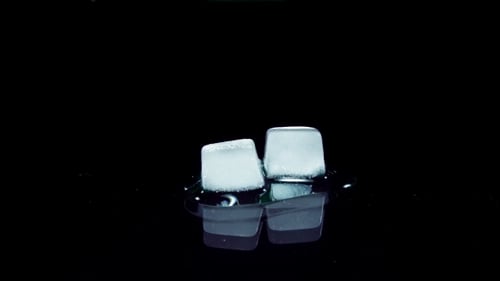 Eiswürfel schmilzt und bewegt sich auf einer Glasoberfläche