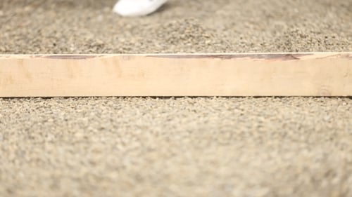Gravel Rocks Being Leveled With Shovel and Board