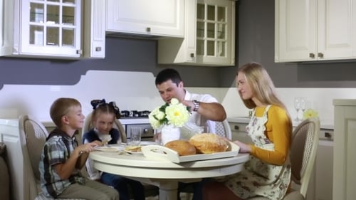 Family Eating Meal Together in Kitchen