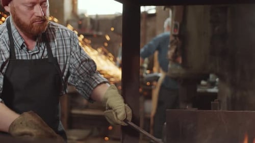 Blacksmith Tending Forge Fire in Workshop
