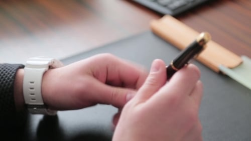 Geschäftsmann spricht mit einem Stift in den Händen