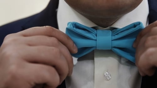 Der Mann passt seine blaue Fliege an