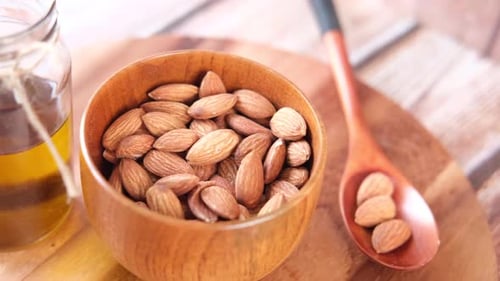 Almond Oil in Bottle on Wooden Background