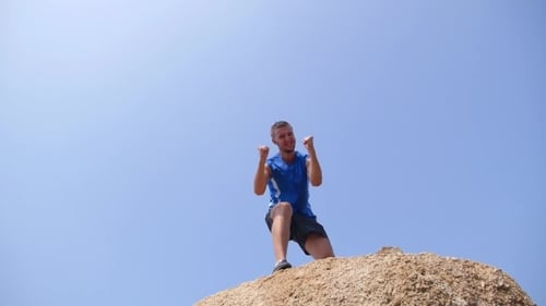 Young Man Celebrating on Mountain Top