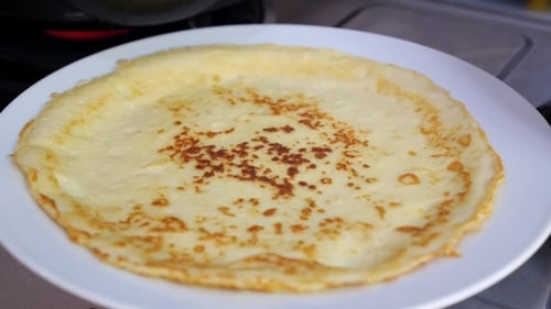 Golden Crepes Stacked on a White Plate