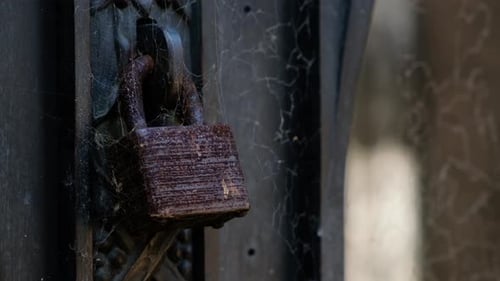 Old rusty padlock surrounded by spider webs close up mistery and occult concept