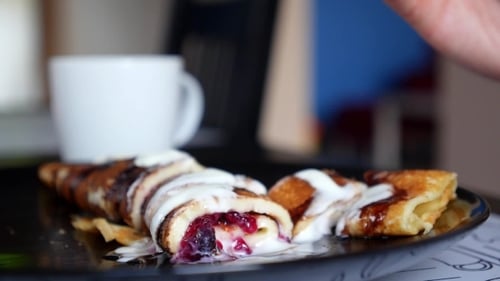 Pancakes with Blueberries on a Plate Being Eaten
