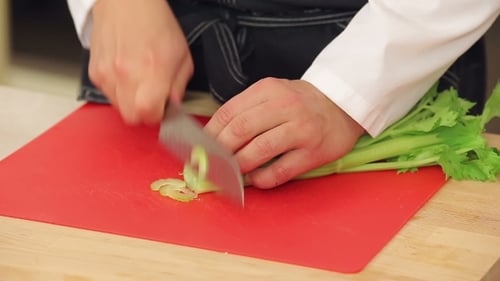 Découper du céleri frais sur une planche à découper