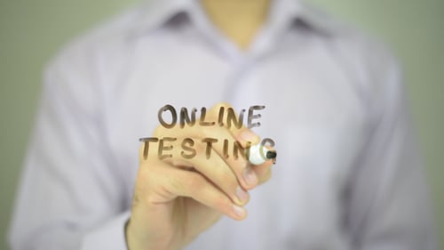 Man Writes Online Testing on Clear Surface