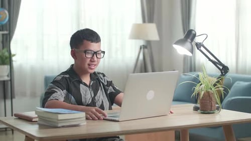 Teen Using Laptop for Online Learning at Home