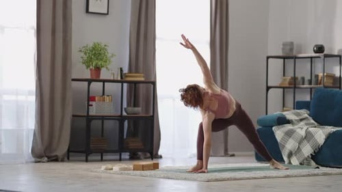 Woman Doing Yoga Pose on Mat Indoors