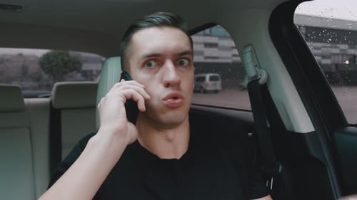 Frustrated man arguing on phone in car