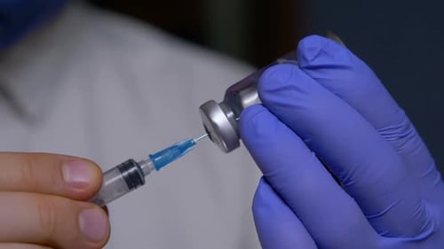 Medical Professional Drawing Medicine Into Syringe Close Up