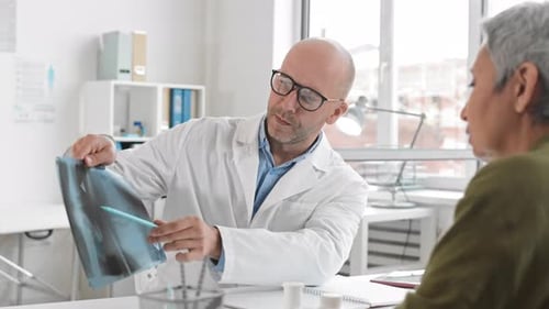 Médico mostrando radiografías al paciente