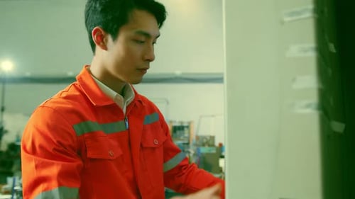 Male Asian engineer professional hand control machine screen in the factory