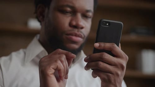 Close Up of a Smartphone in the Hands of a Young Adult Africanamerican Man