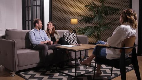 Couple Talking to Counselor in Warmly Lit Office