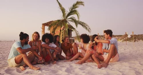 Friends sitting side by side on the beach
