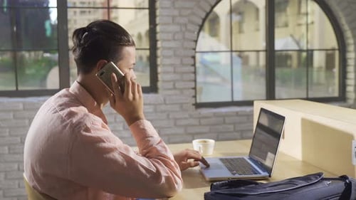 College student talking on phone in cafe.