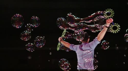 Man Performing Magic with Soap Bubbles at Night