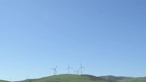 Wind Turbines Spinning on Green Rolling Hills