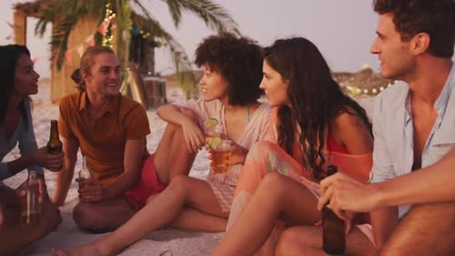 Friends Enjoying Drinks at Beach Party during Sunset