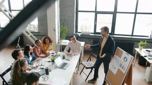 High Angle View of Experienced Businessman Making Presentation for Colleagues in Office