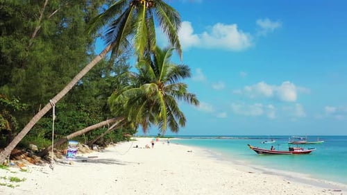 Peaceful seascape with boat floating on shore of tropical island with white sandy beach under shadow