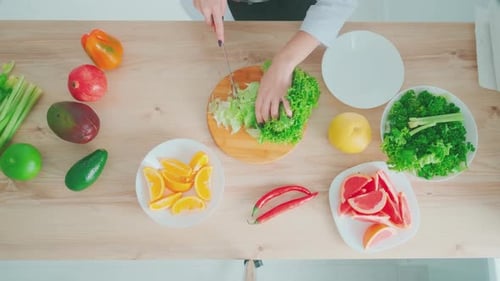 Chef Prepares Salad at Kitchen Table