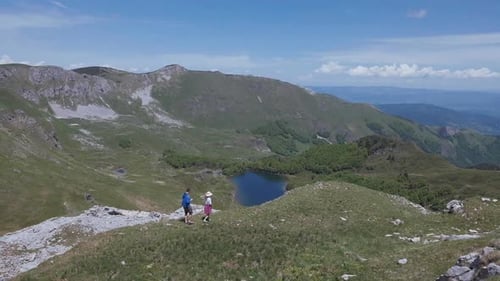 Woman and man walking in the mountains in Montenegro. Couple of tourists travel in Europe