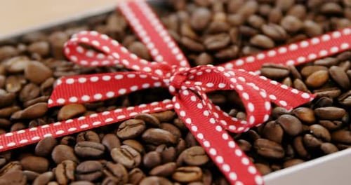 Roasted coffee beans packed with ribbon in box